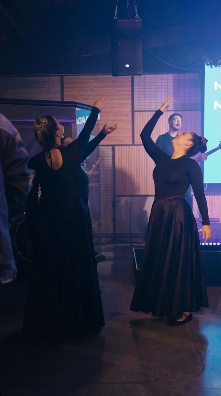 Bailarinas de dança ministerial com os braços erguidos durante o louvor