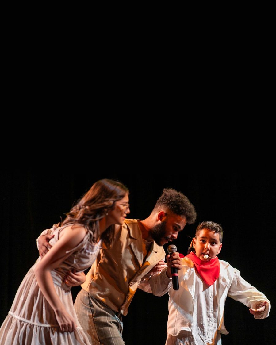 Três alunos de teatro em cena no palco